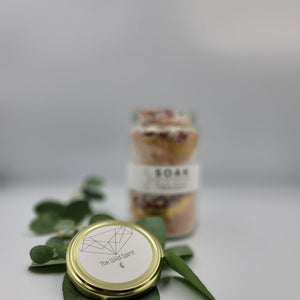Magnesium Salt Soak with Rose Petals, Gold Mica and French Pink Clay. Product Front Lid Feature Detail with Sprig of Eucalyptus 